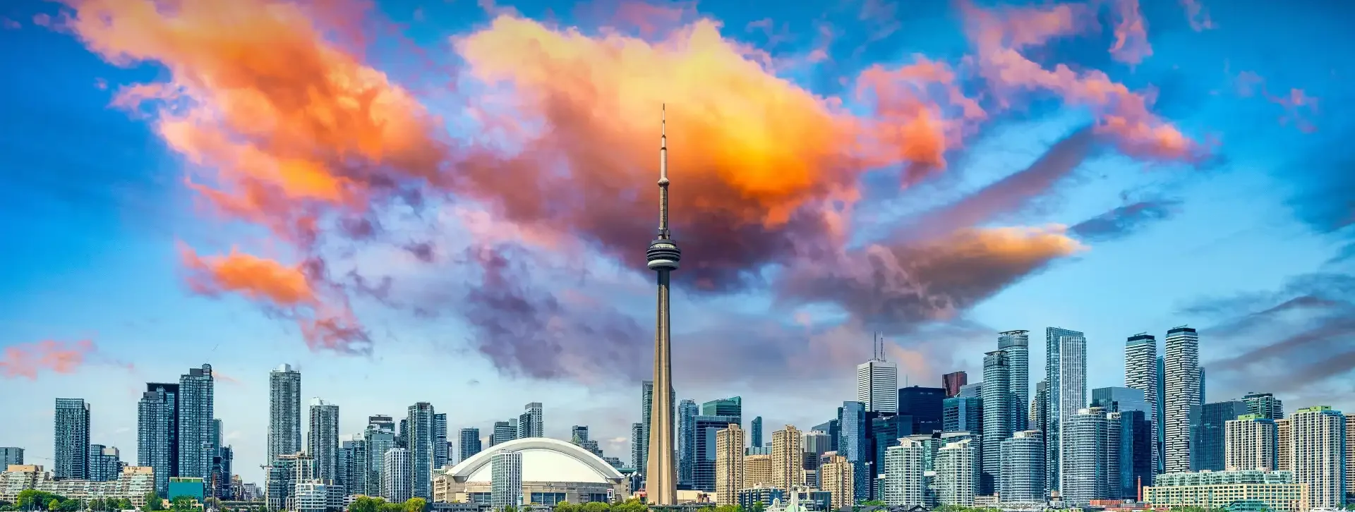 Toronto skyline with the CN Tower under a colourful sky.